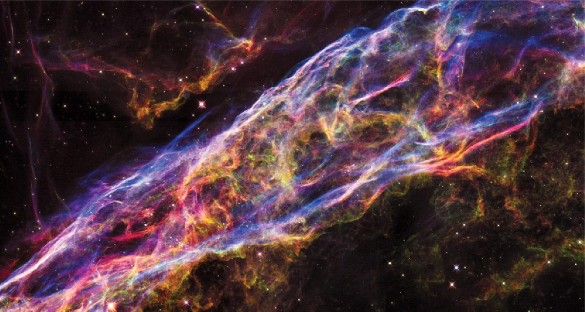 A filament of gas resembles an enormous bubble or surface stretching across the entire image. Stars and smaller gas filaments are also visible in the background.