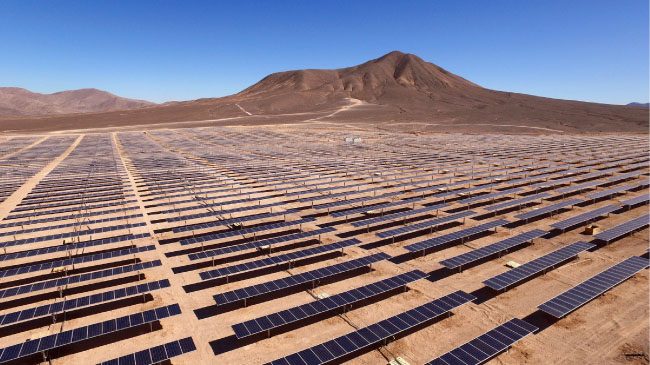 Solar cell arrays lined up in a field.