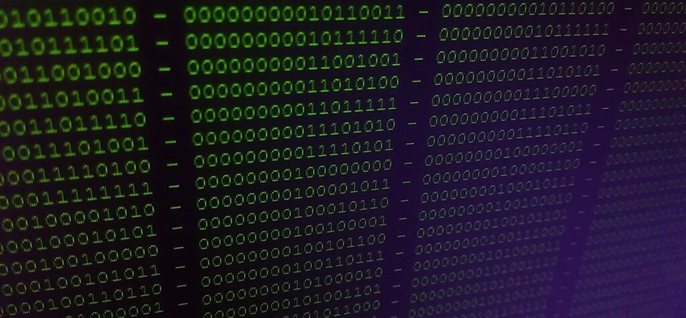 A digital screen displays binary code.