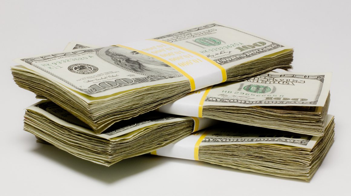 Four bundles of currency notes are stacked one above the other.