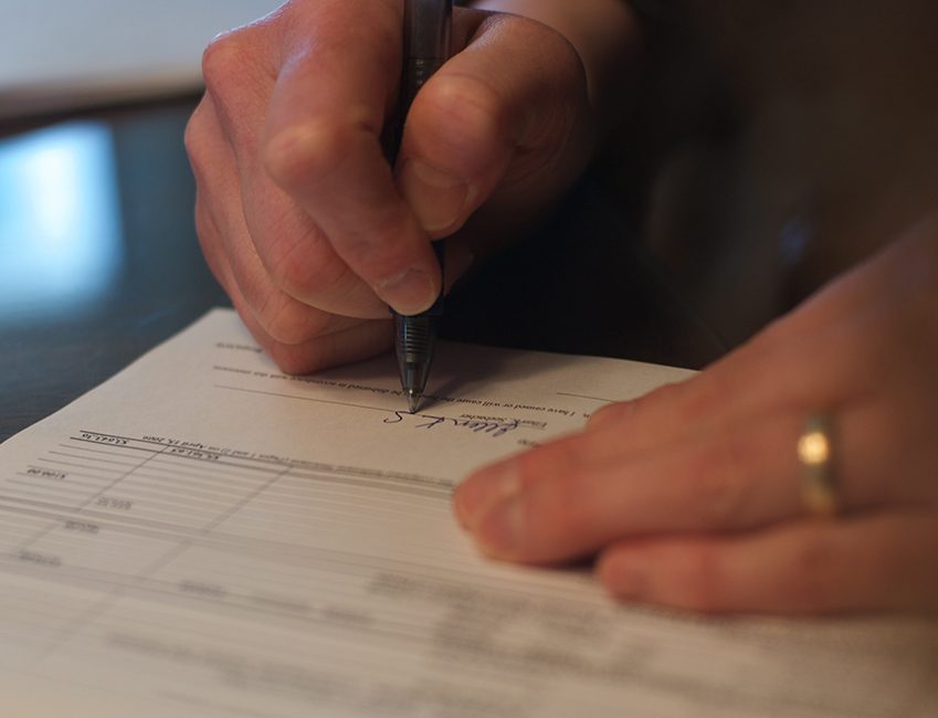 A person is signing a document.