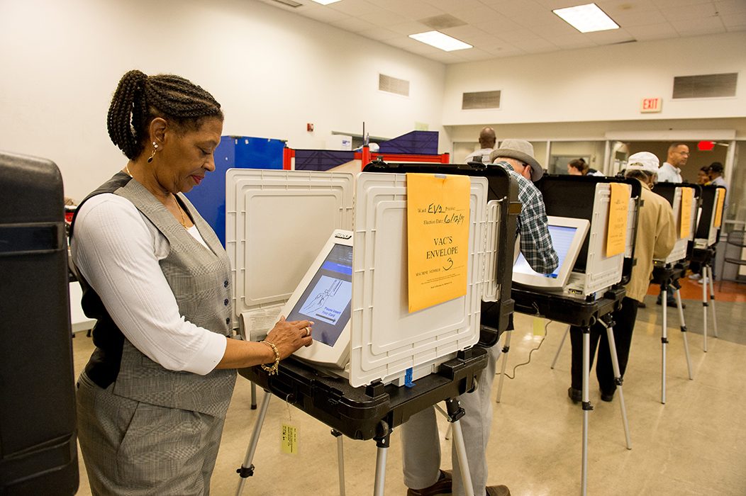 A photo shows two men casting their vote in polling booths.