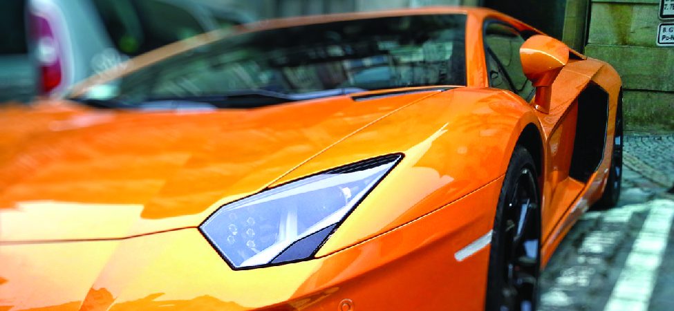 A close up photo of a bright orange Lamborghini Aventador.