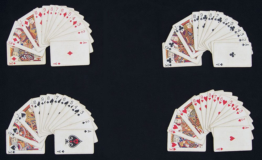 A deck of playing cards sorted by suit into 4 groups. In each group, the visible rank labels run K, Q, J, 10, 9, 8, 7, 6, 5, 4, 3, 2, A.