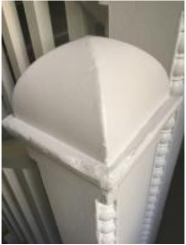 White staircase newel post whose cap curves upward to a central point in an ogive shape, an architectural example of the ogive curve.
