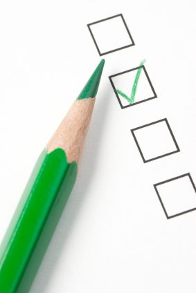 Photograph of a green pencil beside a column of four survey checkboxes, the second one marked with a green check — illustration for the Statistical Literacy item on the American Community Survey.